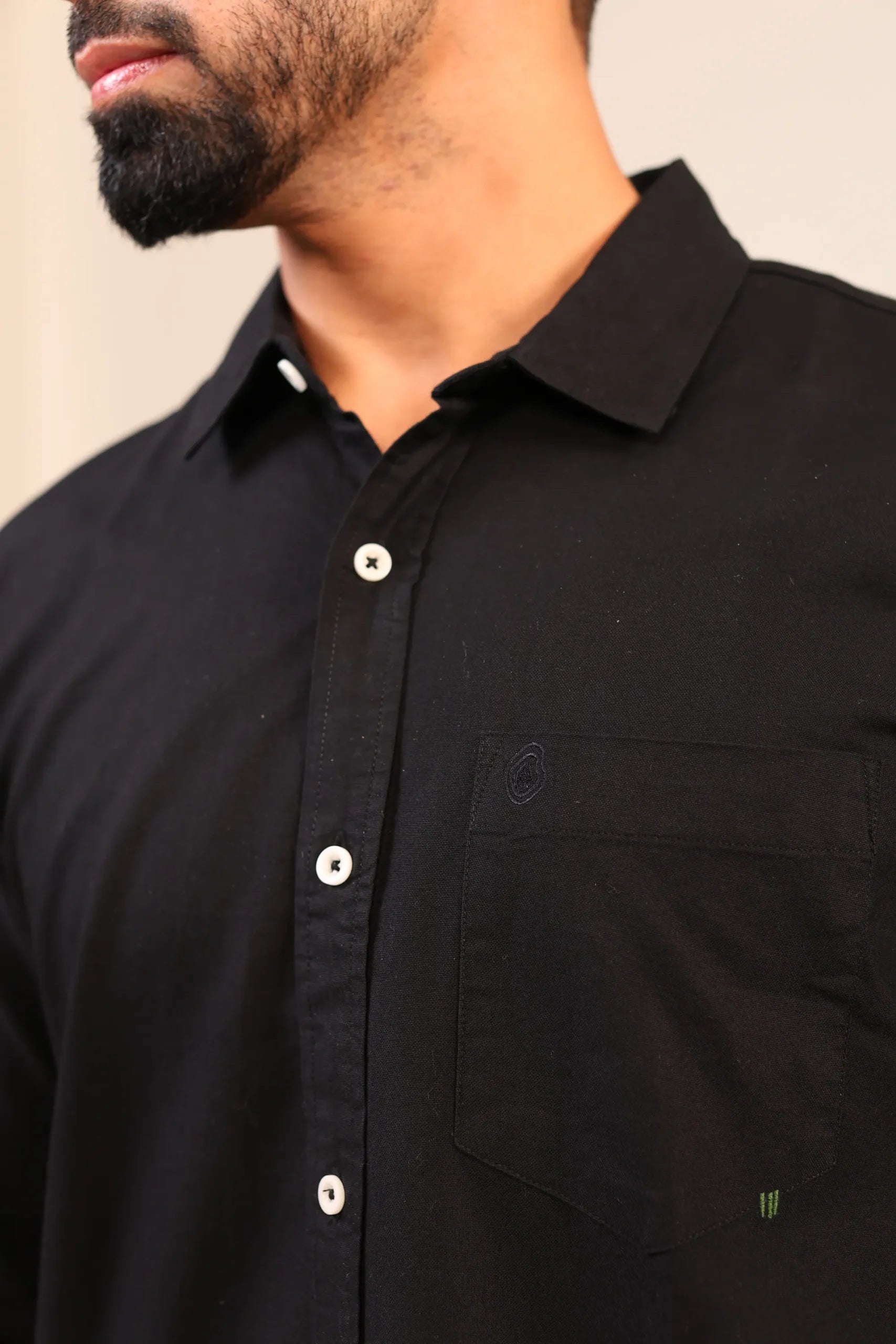Close-up of black shirt collar and top buttons.