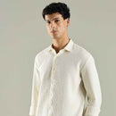 Man wearing a light-colored shirt against a plain background