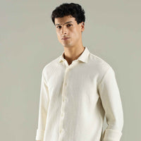 Man wearing a light-colored shirt against a plain background