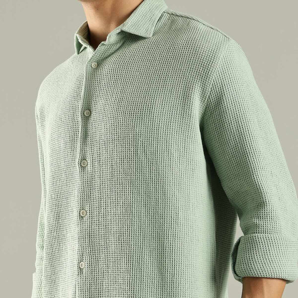 Light green textured shirt worn by a person on a gray background