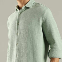 Light green textured shirt worn by a person on a gray background