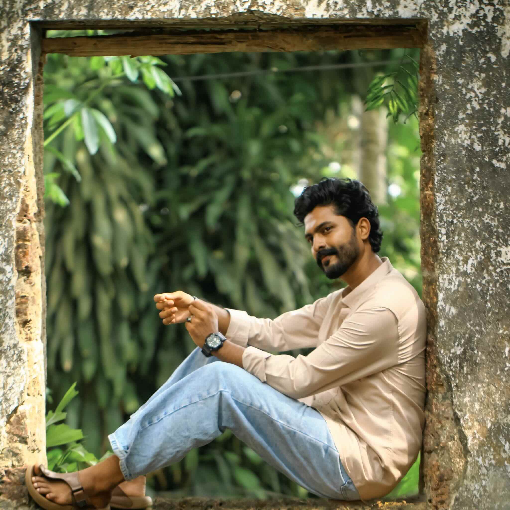 Man wearing sandstone shirt and sitting outdoors with a rustic frame around him