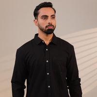 Man wearing a black shirt against a neutral background