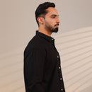 Man wearing a black shirt against a beige background