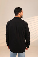Rear view of man in black shirt under soft lighting.
