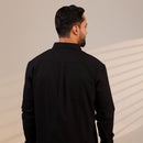 Man wearing a black shirt against a neutral background