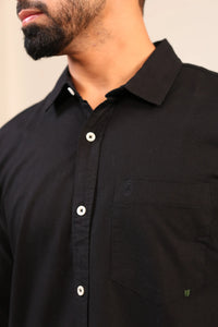 Close-up of black shirt collar and top buttons.