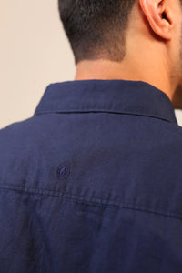 Close-up of navy shirt collar and neck stitching.