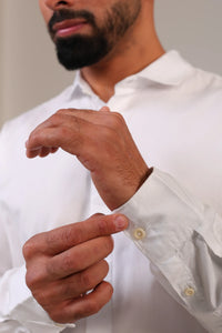 Close-up of man adjusting a white shirt cuff.