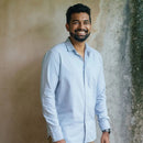 Man wearing a light blue shirt with a neutral background