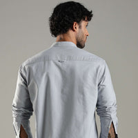 Man wearing a light blue shirt against a plain background