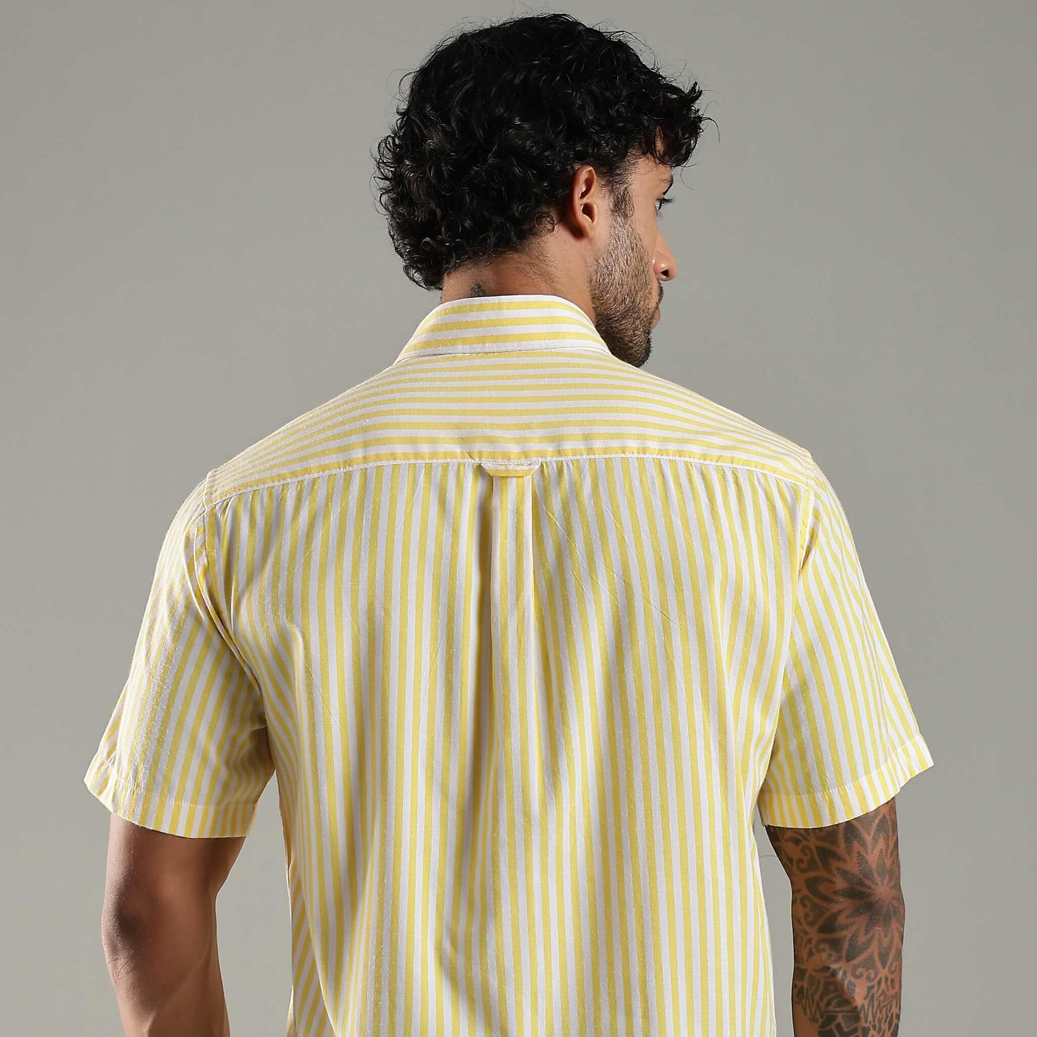 Man wearing a yellow striped shirt against a gray background