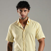 Man wearing a yellow striped shirt against a gray background
