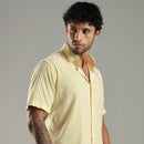 Man wearing a yellow striped shirt against a gray background