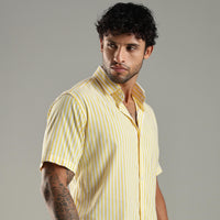 Man wearing a yellow striped shirt against a gray background