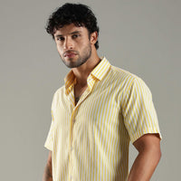 Man wearing a yellow striped shirt against a gray background