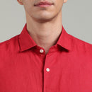 Red linen shirt worn by a person on a gray background