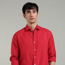 Man wearing a red linen shirt against a gray background
