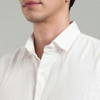 Close-up of a person wearing a white hemp shirt against a gray background