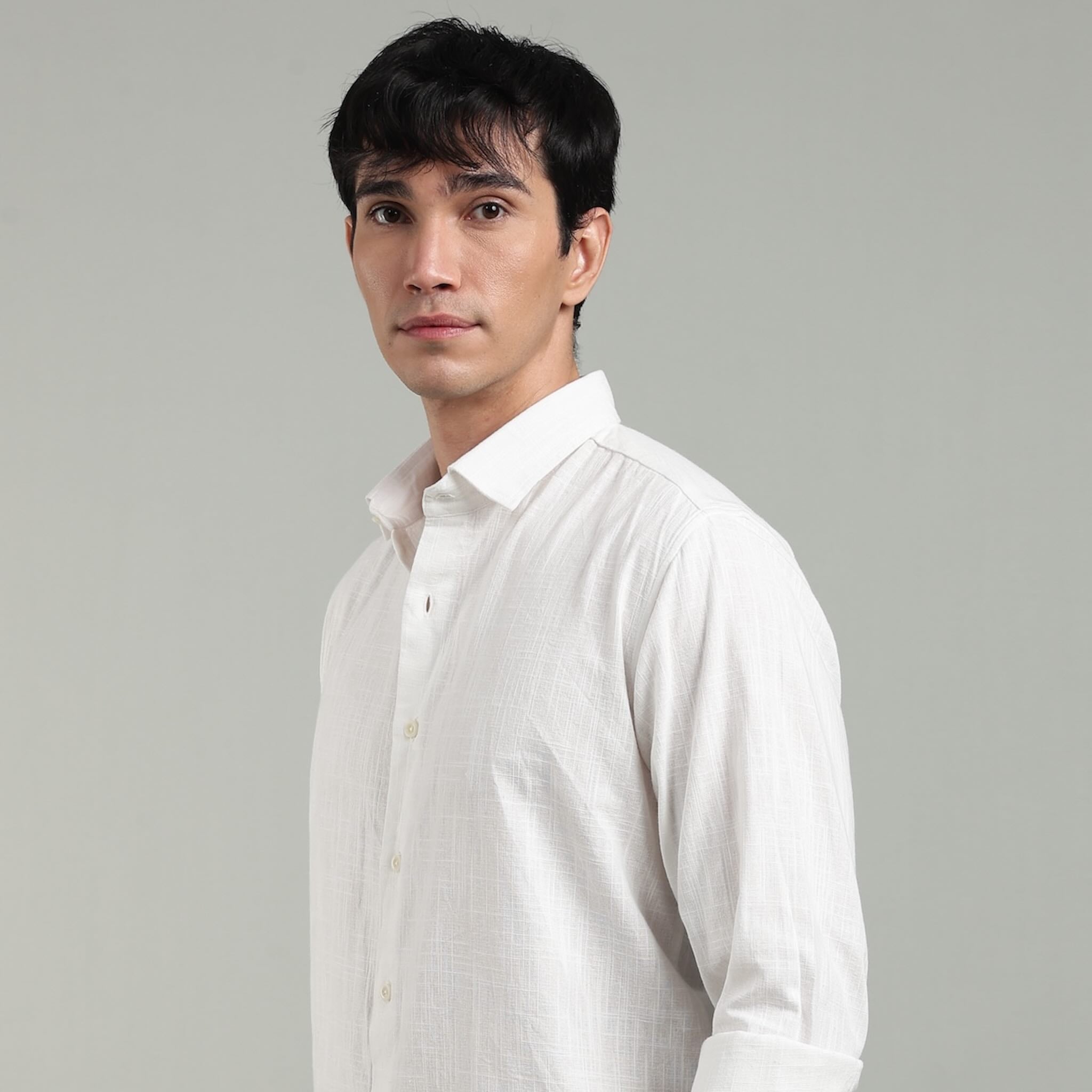 Man wearing a white hemp shirt against a gray background