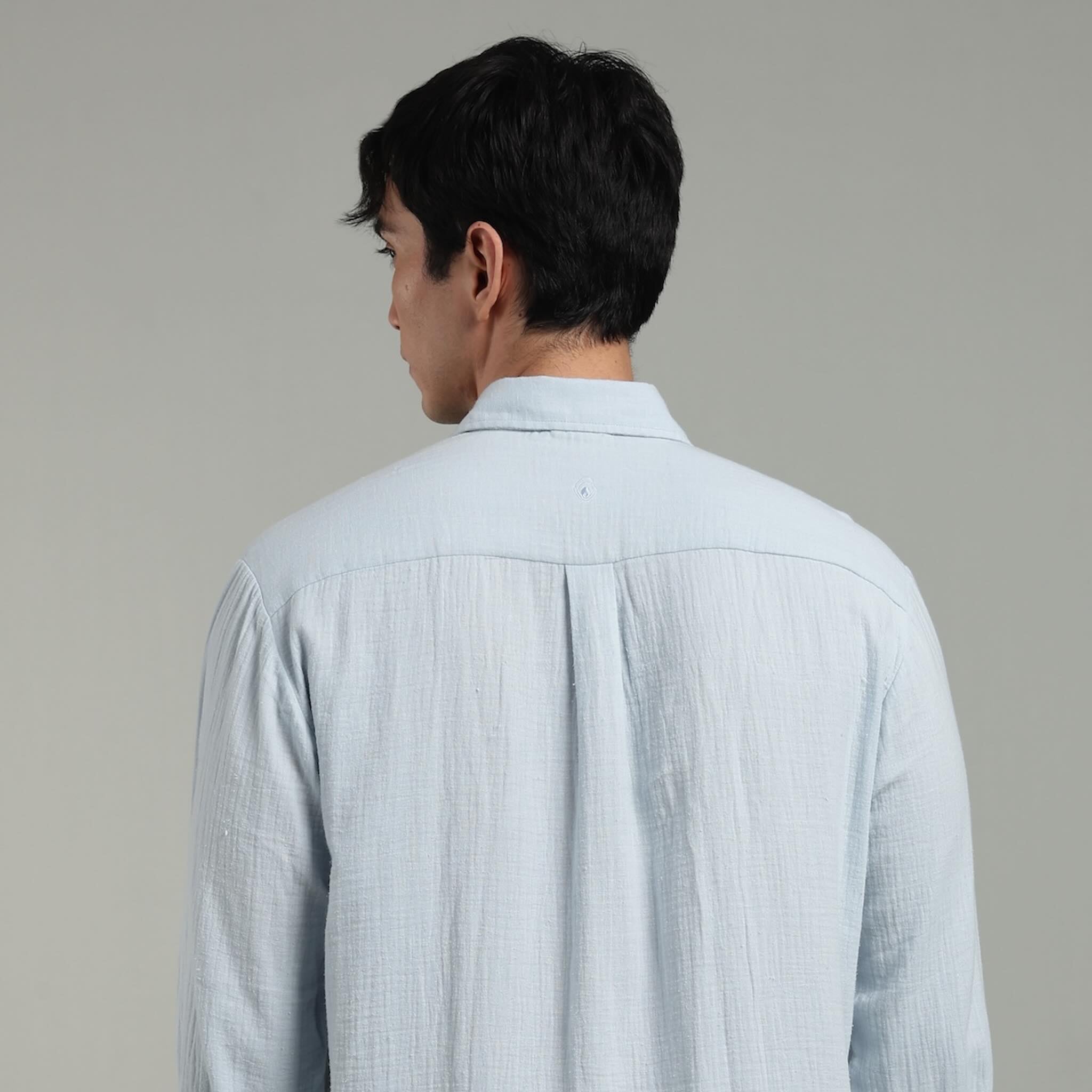 Man wearing a light blue shirt against a plain background