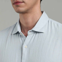Light blue  shirt worn by a person on a gray background