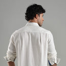Man wearing a white shirt against a gray background