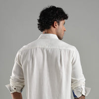 Man wearing a white shirt against a gray background
