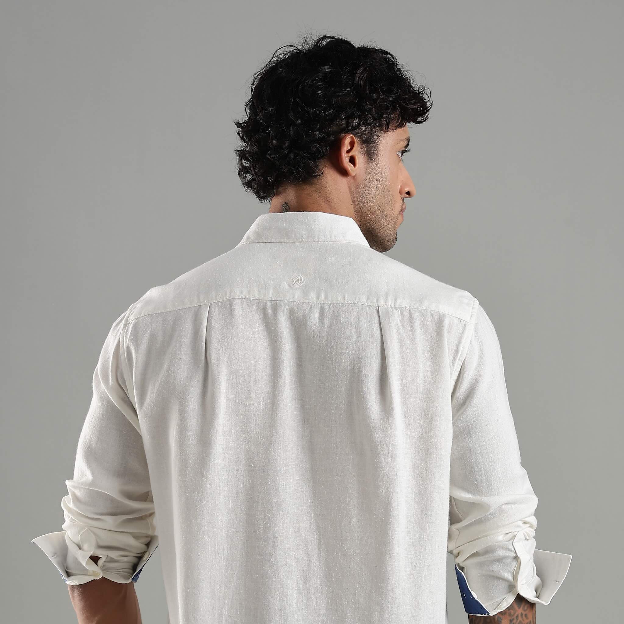 Man wearing a white shirt against a gray background