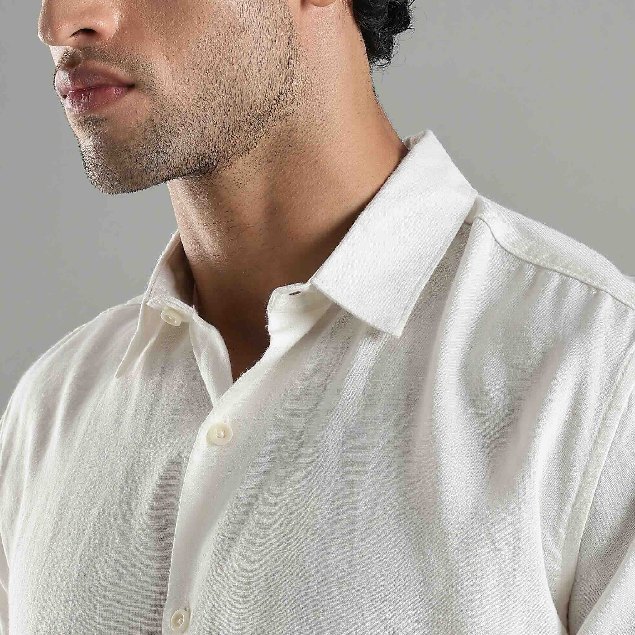 Man wearing a light-colored shirt against a neutral background