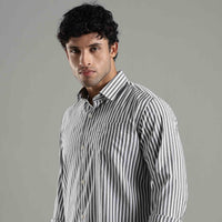 Man wearing a striped shirt against a gray background