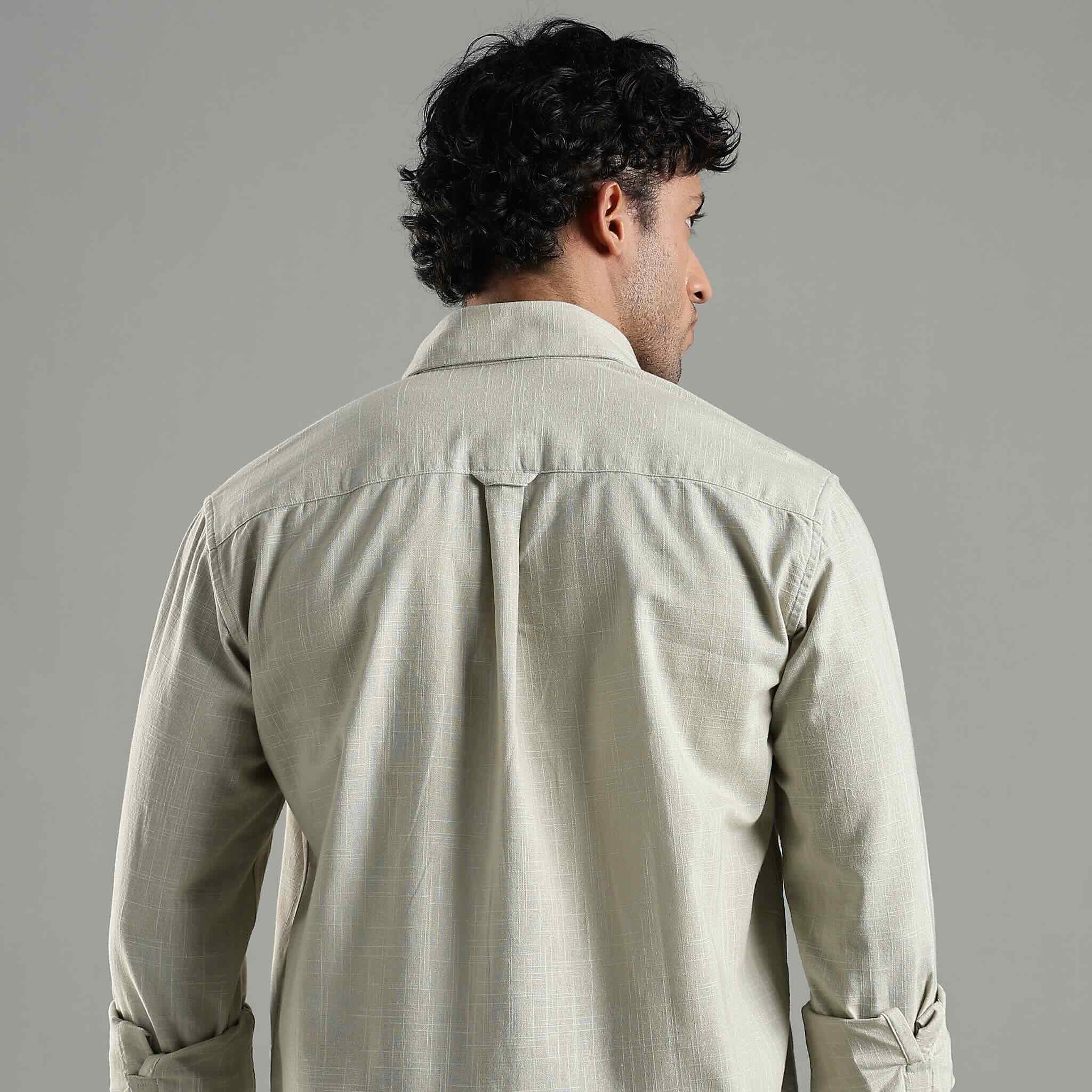 Man wearing a green shirt against a gray background