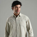 Man wearing a light green shirt against a gray background