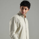 Man wearing a light green shirt against a gray background