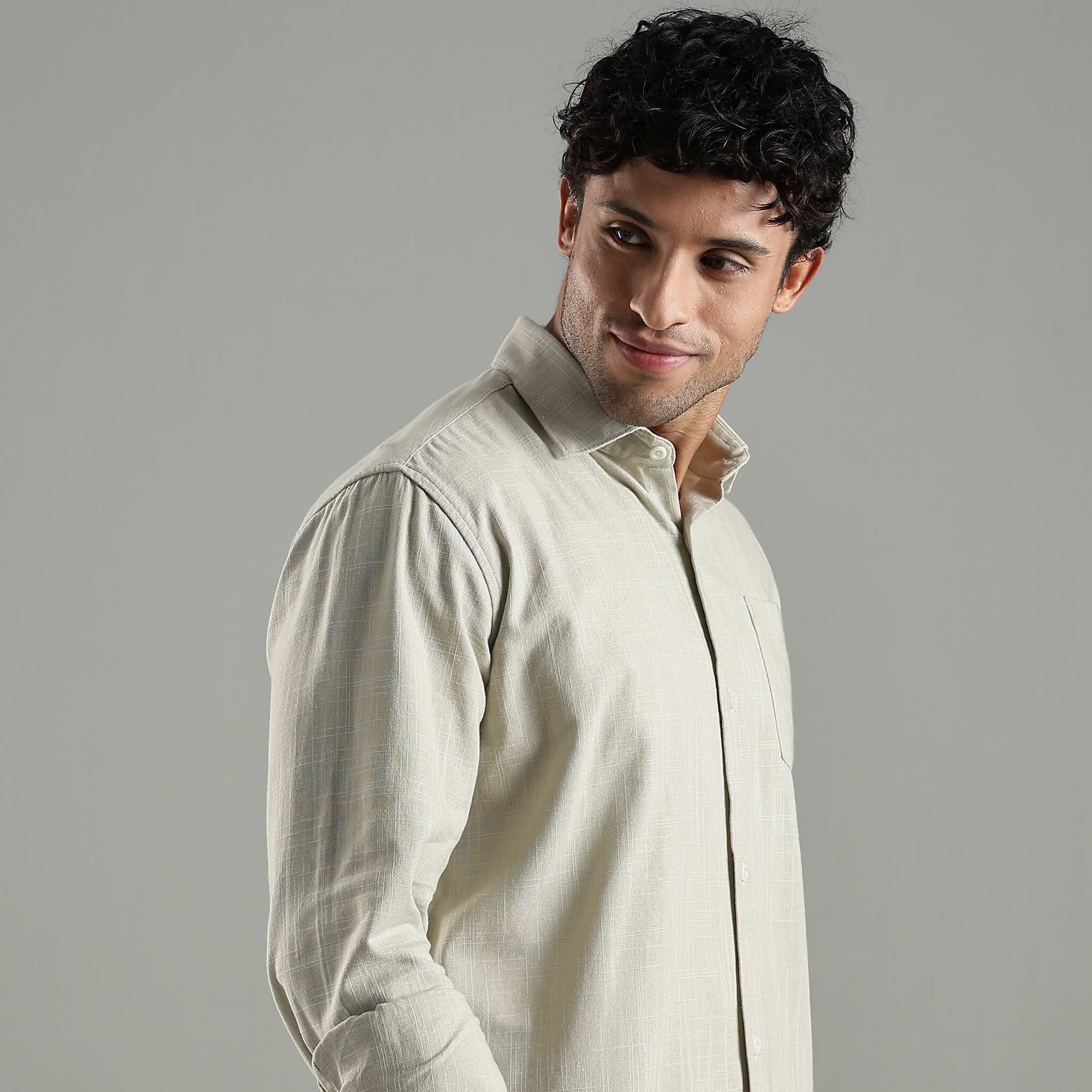 Man wearing a light green shirt against a gray background