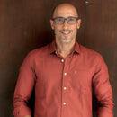 Man wearing a red shirt against a brown background