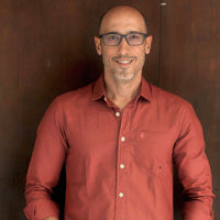 Man wearing a red shirt against a brown background