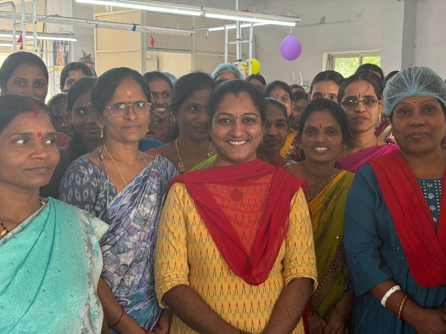 Group of women in a factory setting, happy and proud about their work.