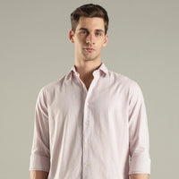 Man wearing a light pink shirt hemp against a plain background