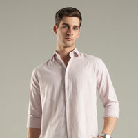 Man wearing a light pink hemp shirt against a plain background
