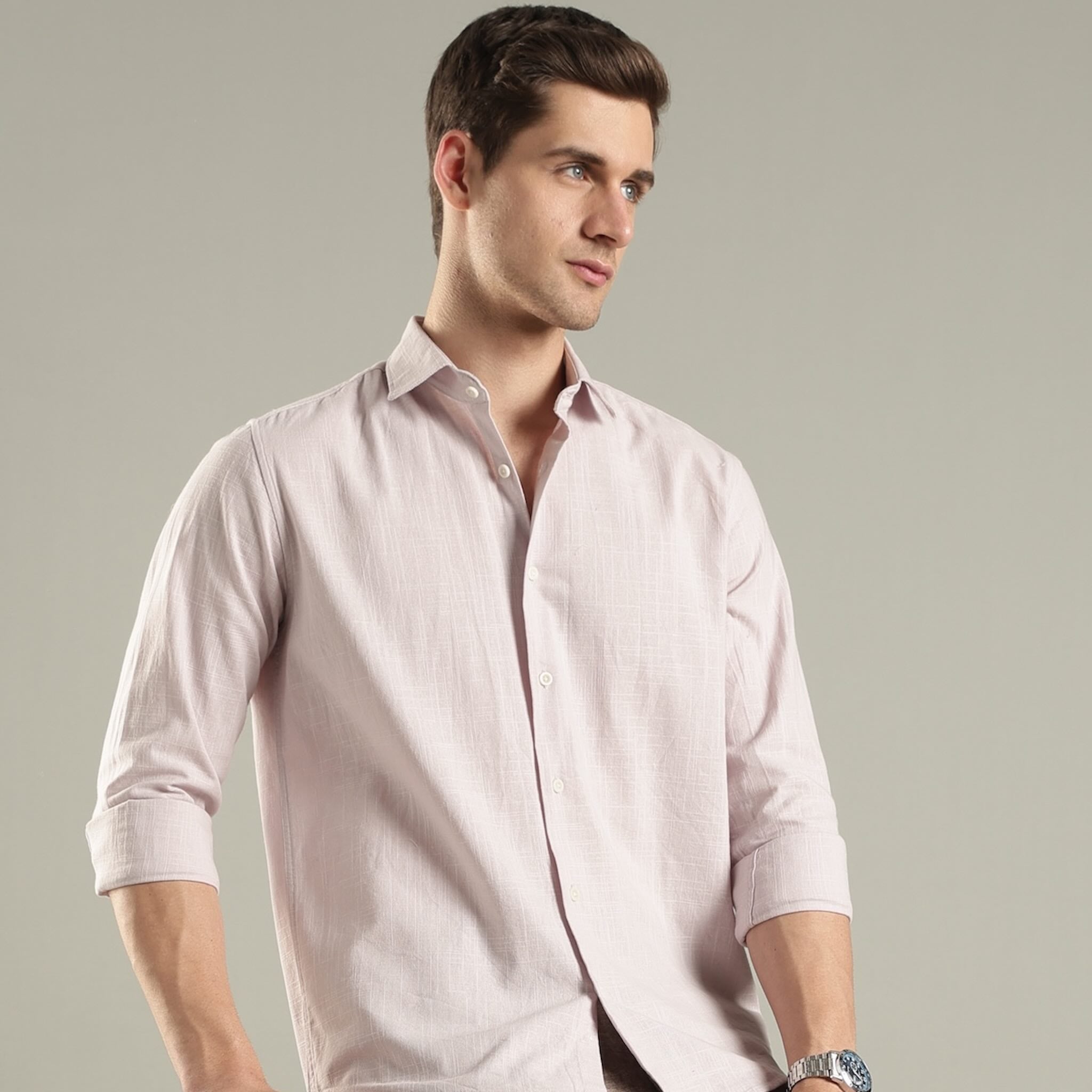 Man wearing a light pink shirt hemp 
against a plain background