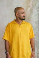 Man in yellow shirt looking sideways