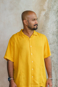 Man in yellow shirt looking sideways